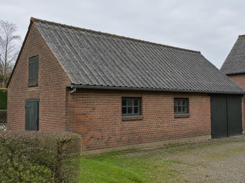 Grijs asbestleiendak op een bijgebouw vóór de verwijdering door Merchiers Dak en Woningrenovatie